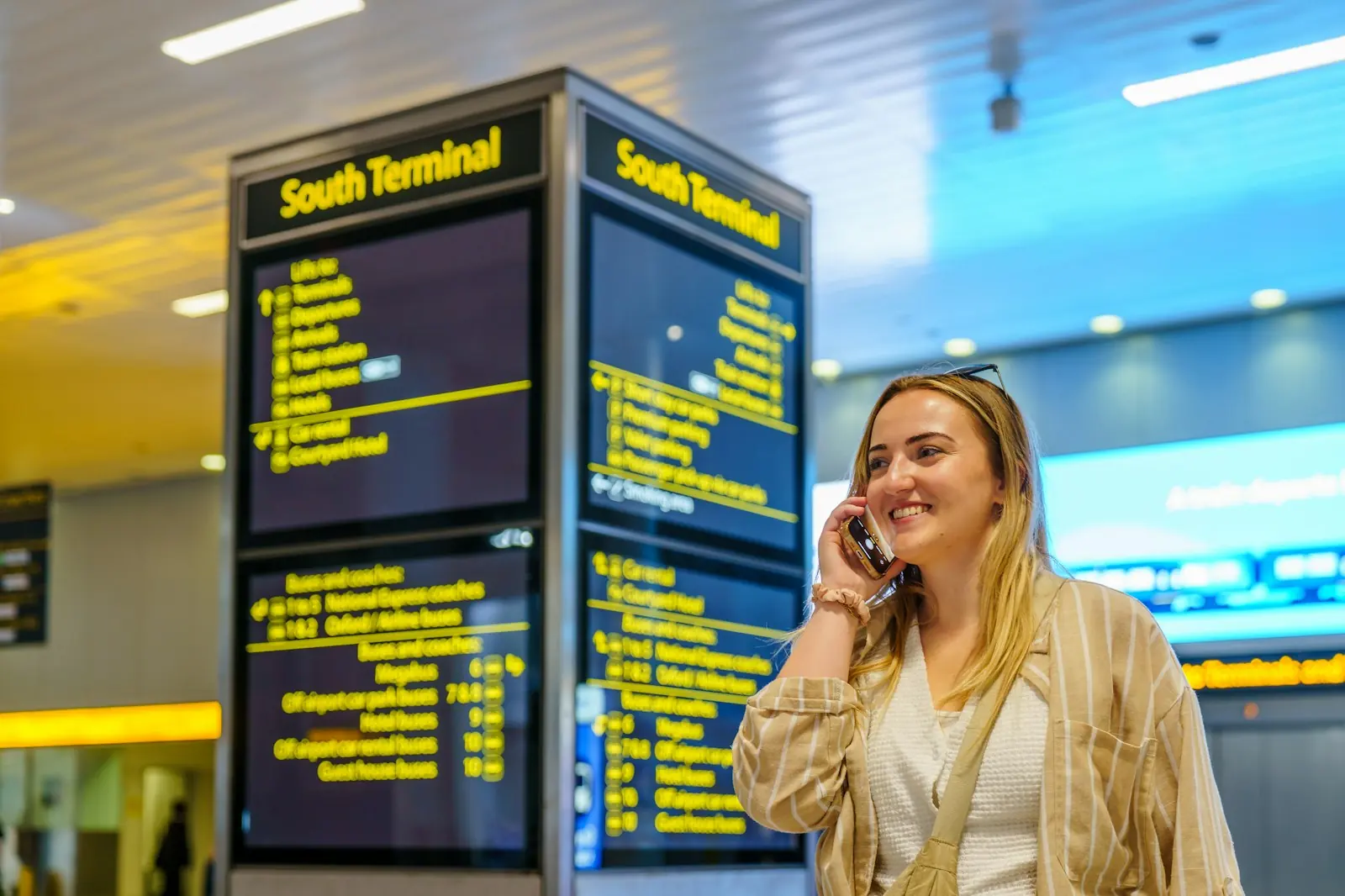 Ondernemer belt met zijn telefoon op het vliegveld